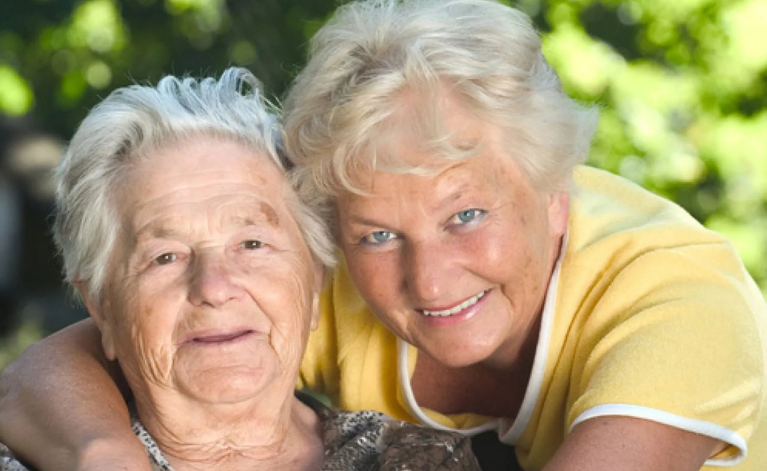 Deux personnes âgées souriante qui regarde l'objectif