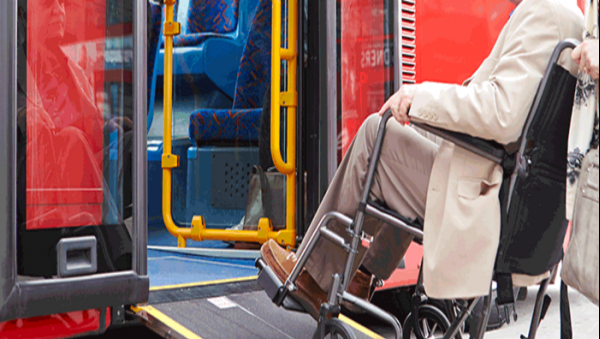 Femme en fauteuil montant une rampe de bus