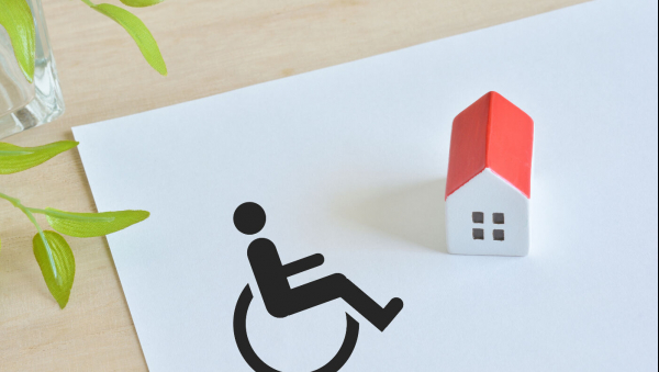 Logo du handicap avec une petite maison en carton à côté